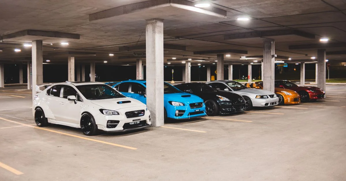 Une variété de voitures de sport garées dans un garage urbain moderne la nuit.