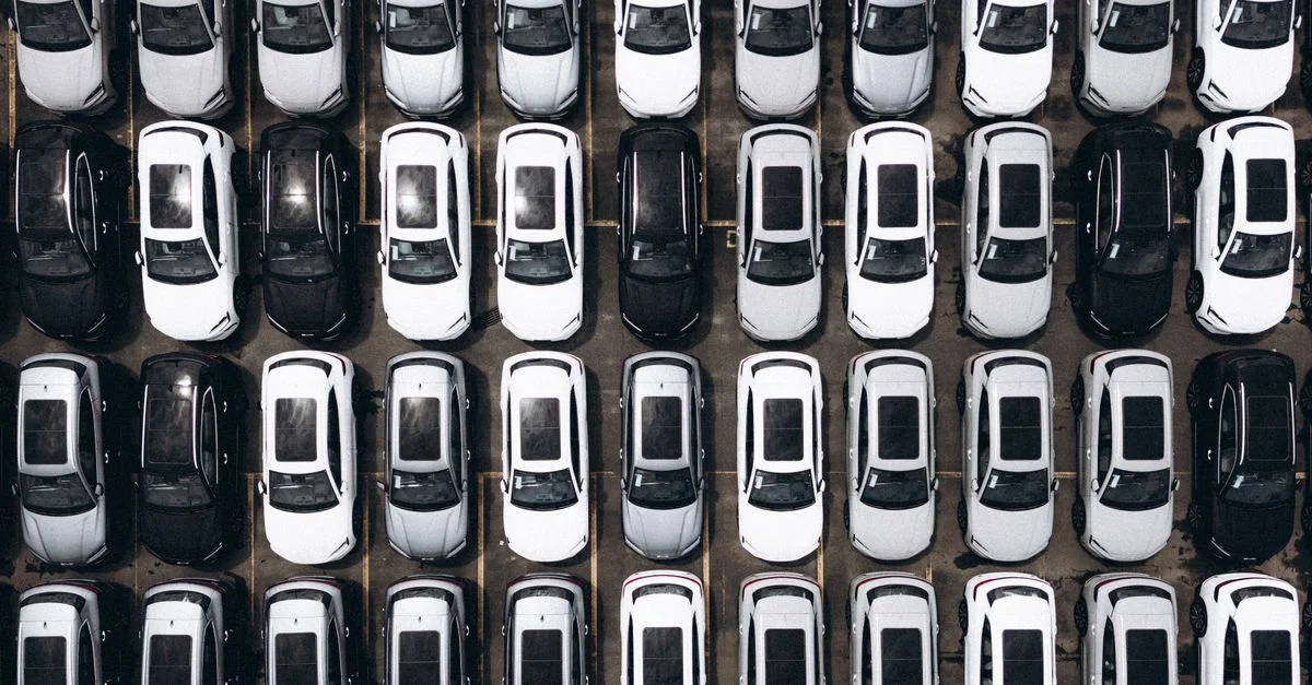 Vue aérienne d'un parking avec des rangées de voitures stationnées au Brésil, mettant en avant l'organisation et la modernité.