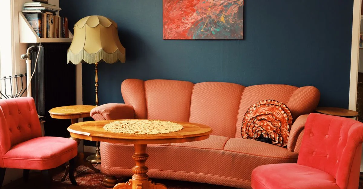 Un salon chaleureux de style vintage à Jönköping, avec des sièges en velours rose.